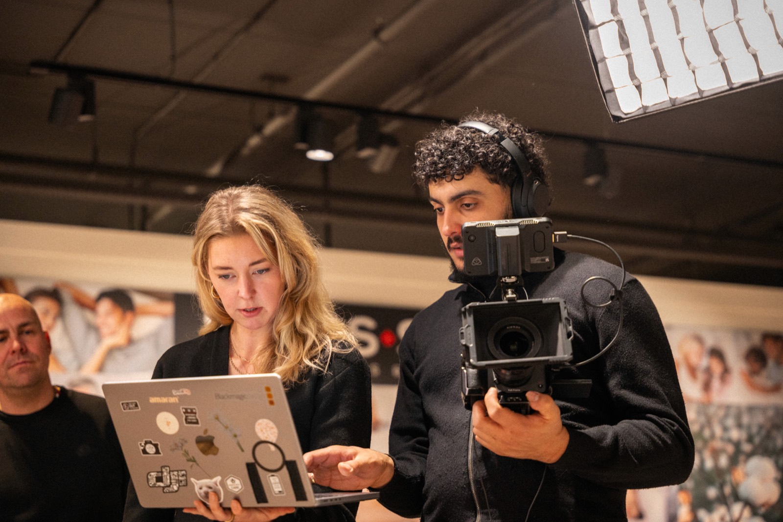 Twee mensen van De Videofabriek aan het werk op locatie, camera en laptop